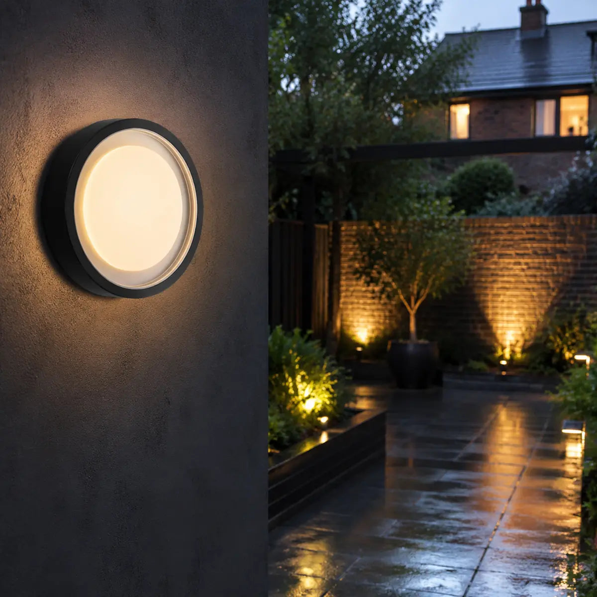 Lumosphere black round outdoor wall lamp illuminating a garden entrance with warm white light
