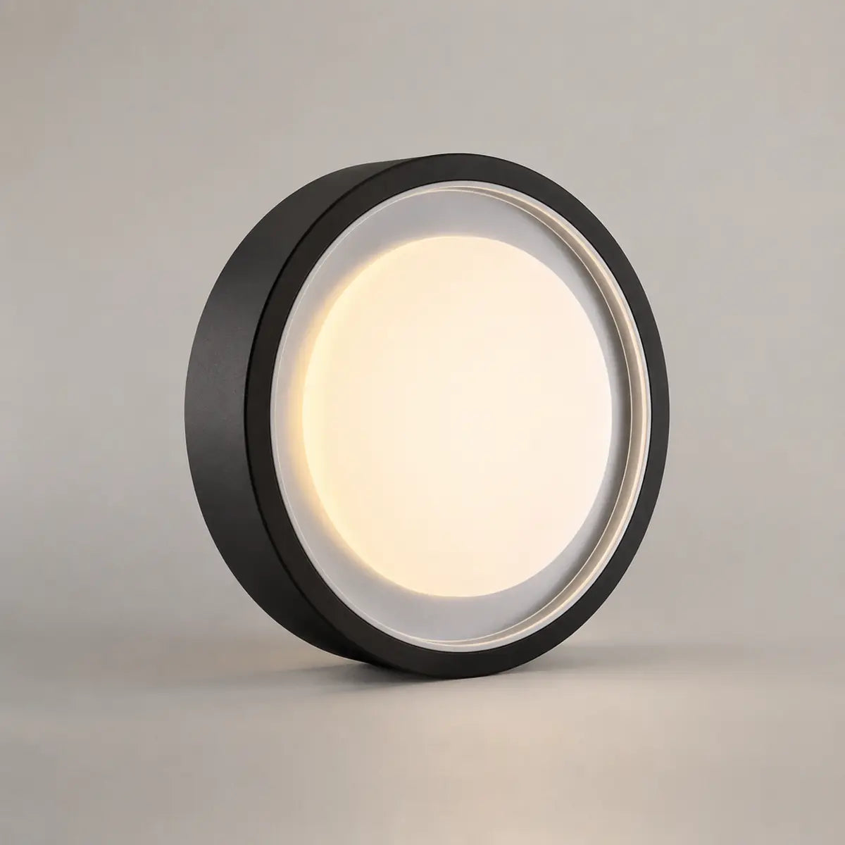 Lumosphere black circular metal light with a warm white diffuser, shown in a studio product view