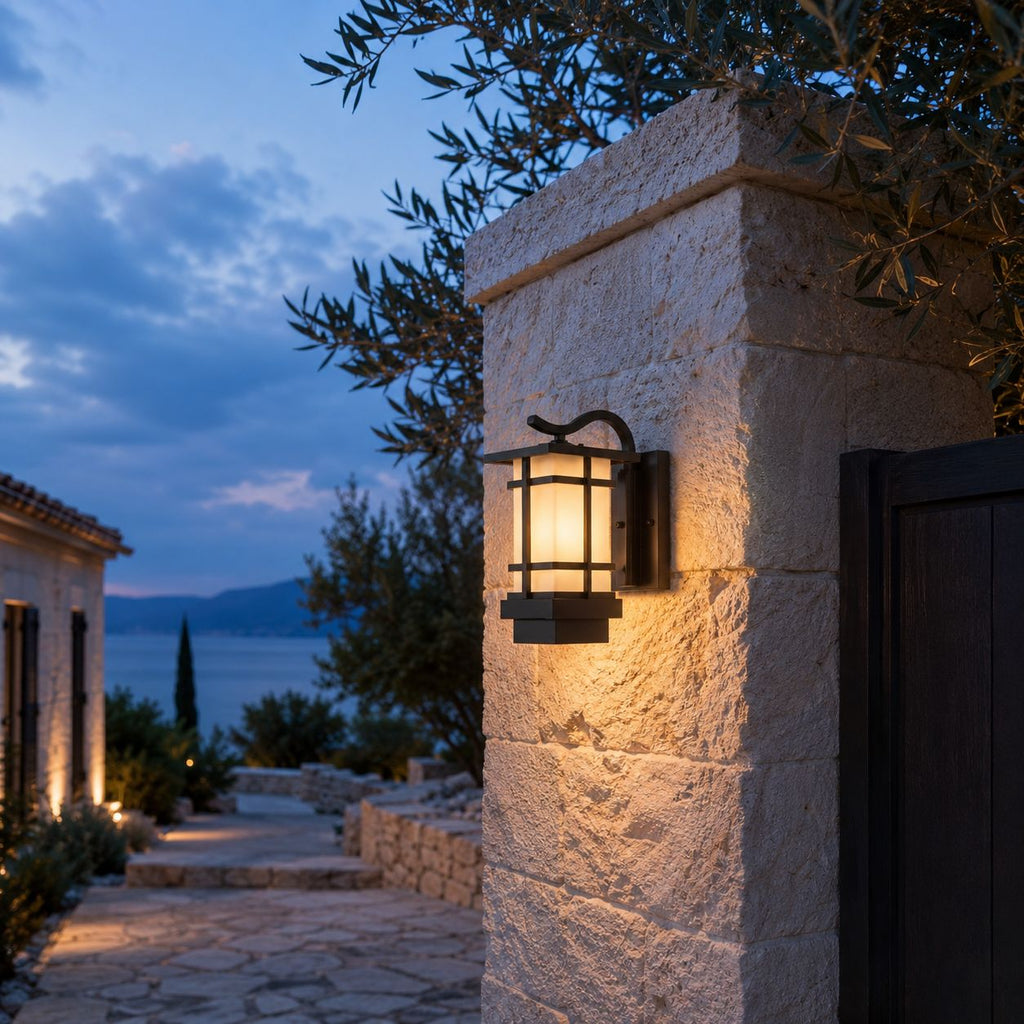 Craftsman wall lantern on a stone pillar with a sea view and olive tree behind