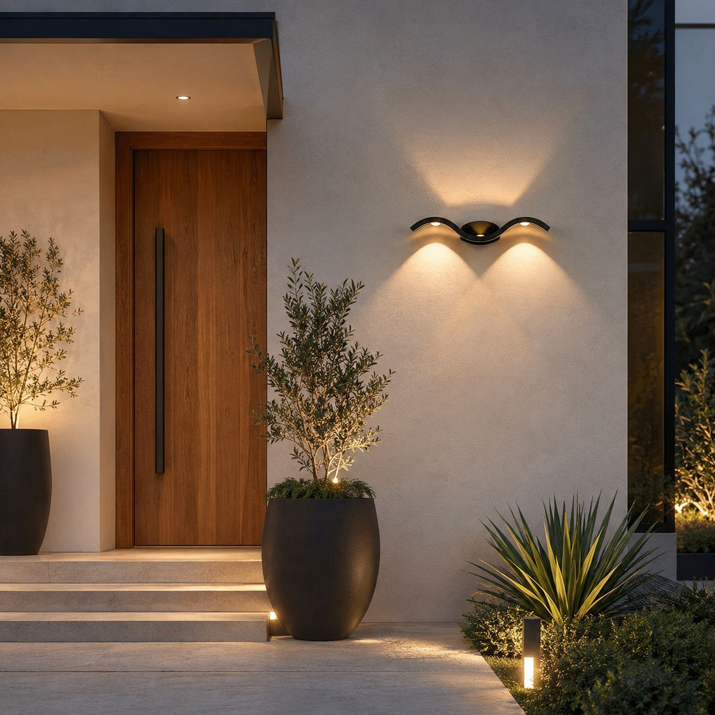 Wave wall light on white render above steps to a timber door with olive trees
