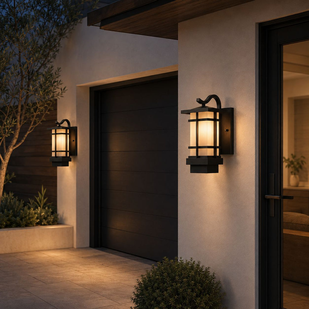 Two craftsman lanterns beside a garage door and entrance on a rendered house