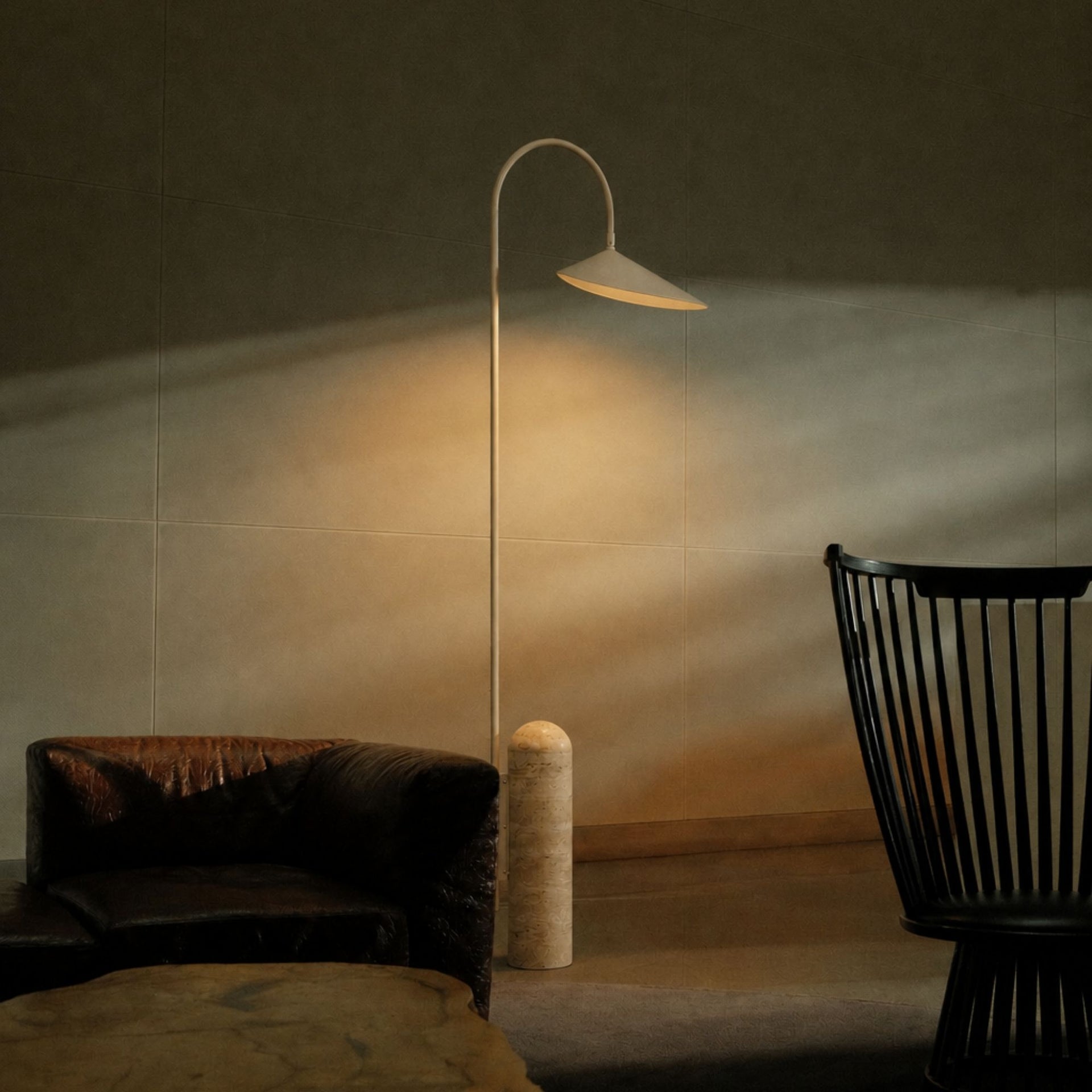 Modern beige floor lamp with marble base in living room corner providing warm ambient lighting