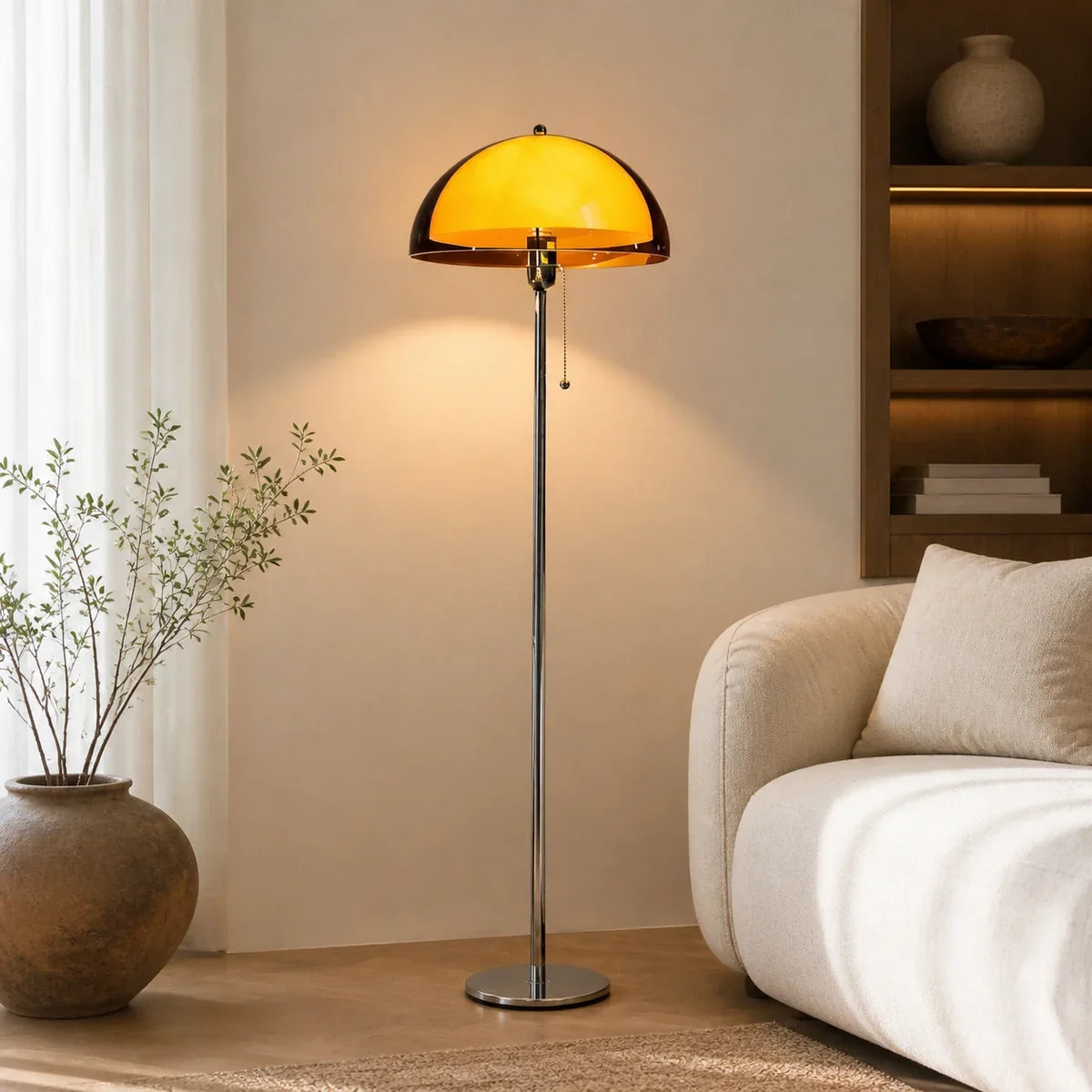 Amber mushroom floor lamp with chrome pole and round metal base beside a cream sofa