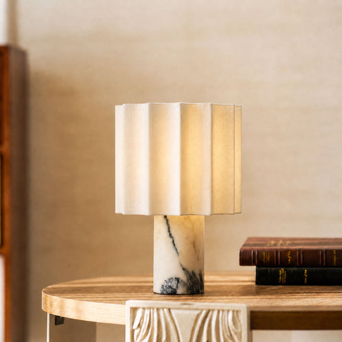 Portable Calacatta marble table lamp with linen shade on side table creating warm ambient lighting
