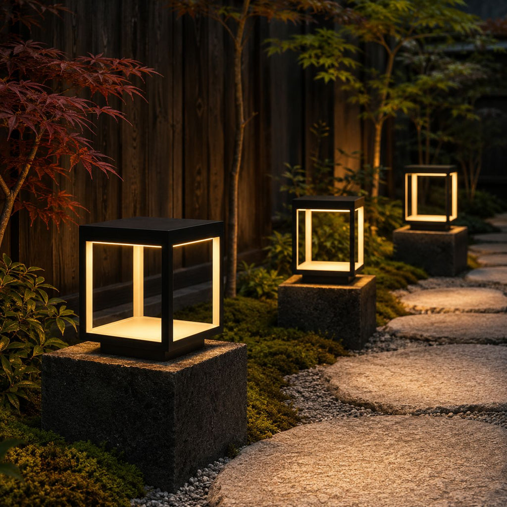 Three modern pillar lights on granite caps lighting a stepping stone garden path