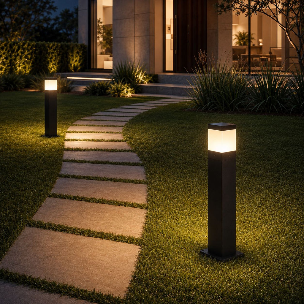 Two bollard lights lighting a stepping stone path across a lawn