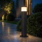 Bollard light in the rain on wet paving, light reflecting off the wet surface