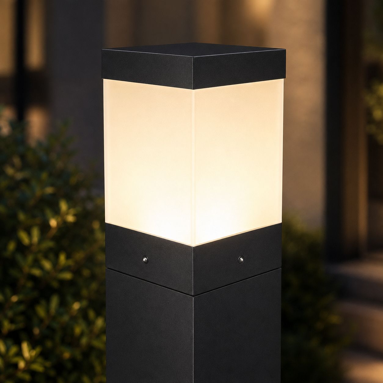 Close-up of the opal acrylic head and chamfered black cap of the bollard light