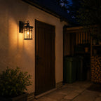 Caged glass wall lantern lighting a timber side door and passage