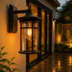 Caged glass wall lantern beside glazed doors onto a lit garden