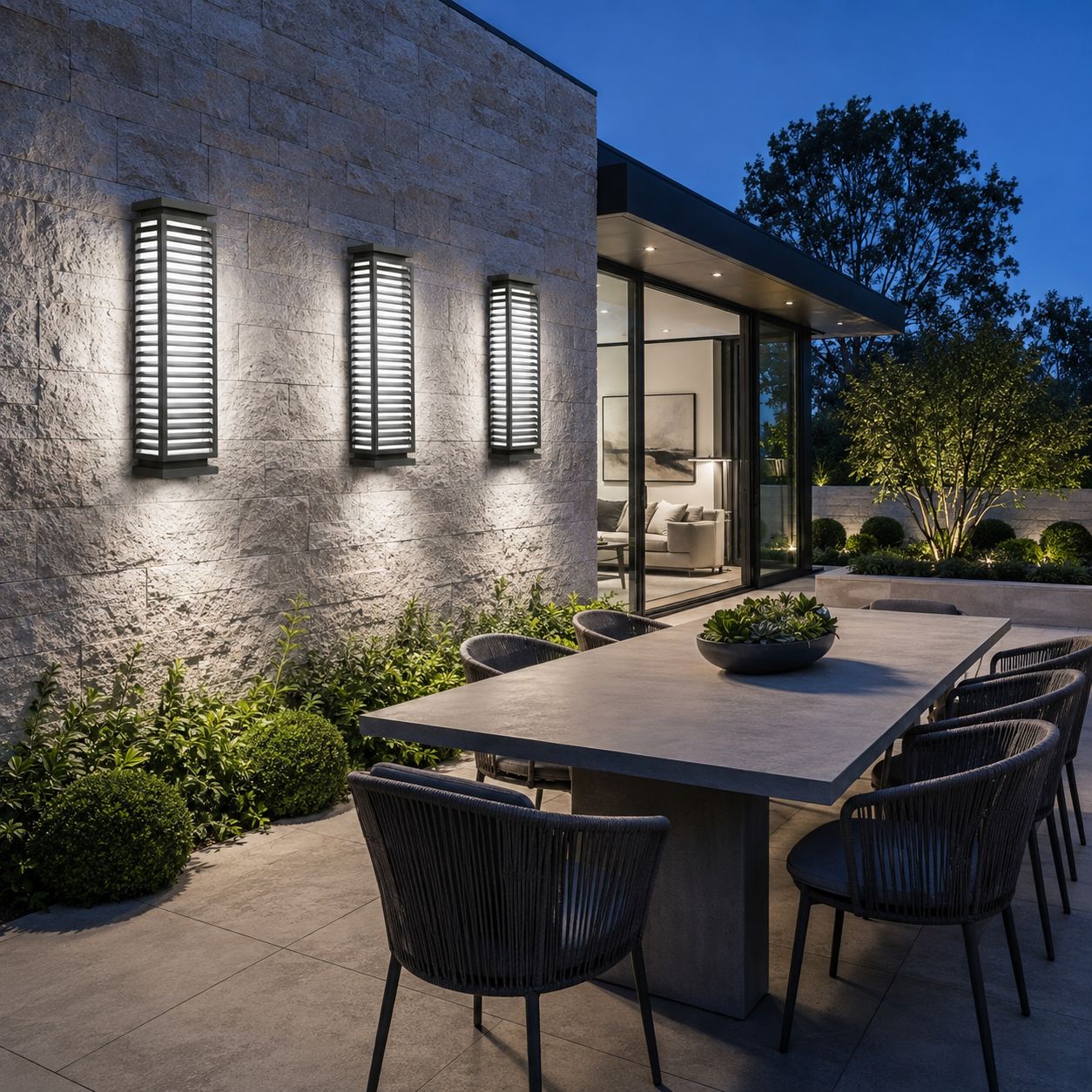 Louvre wall lights on a textured wall above an outdoor dining table