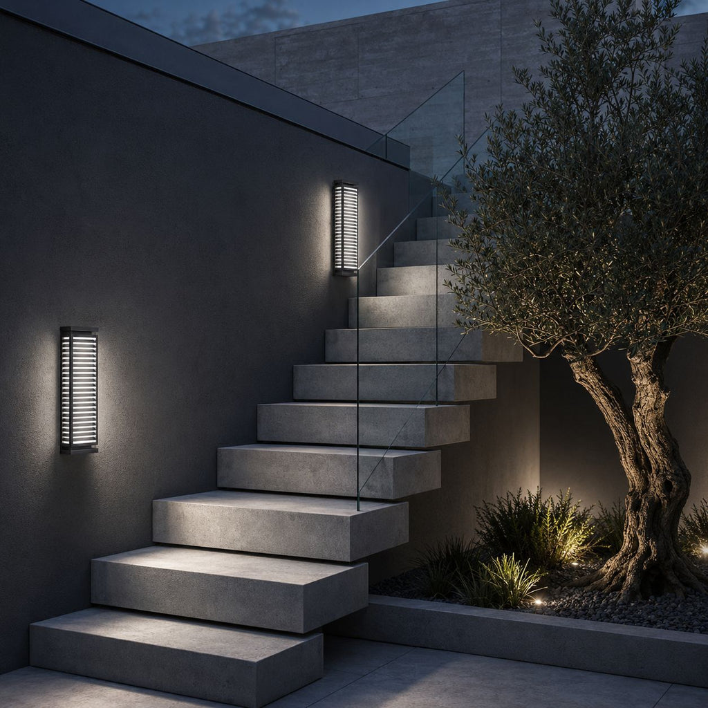Louvre wall light beside stone steps with an olive tree at dusk