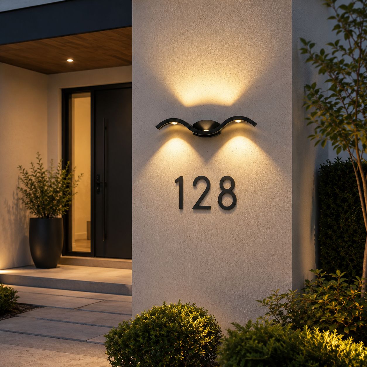 Black wave wall light lighting a white entrance wall with the house number 128