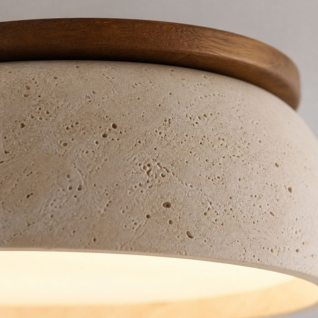 Macro close-up of beige travertine ceiling light surface highlighting natural stone pores and warm LED glow