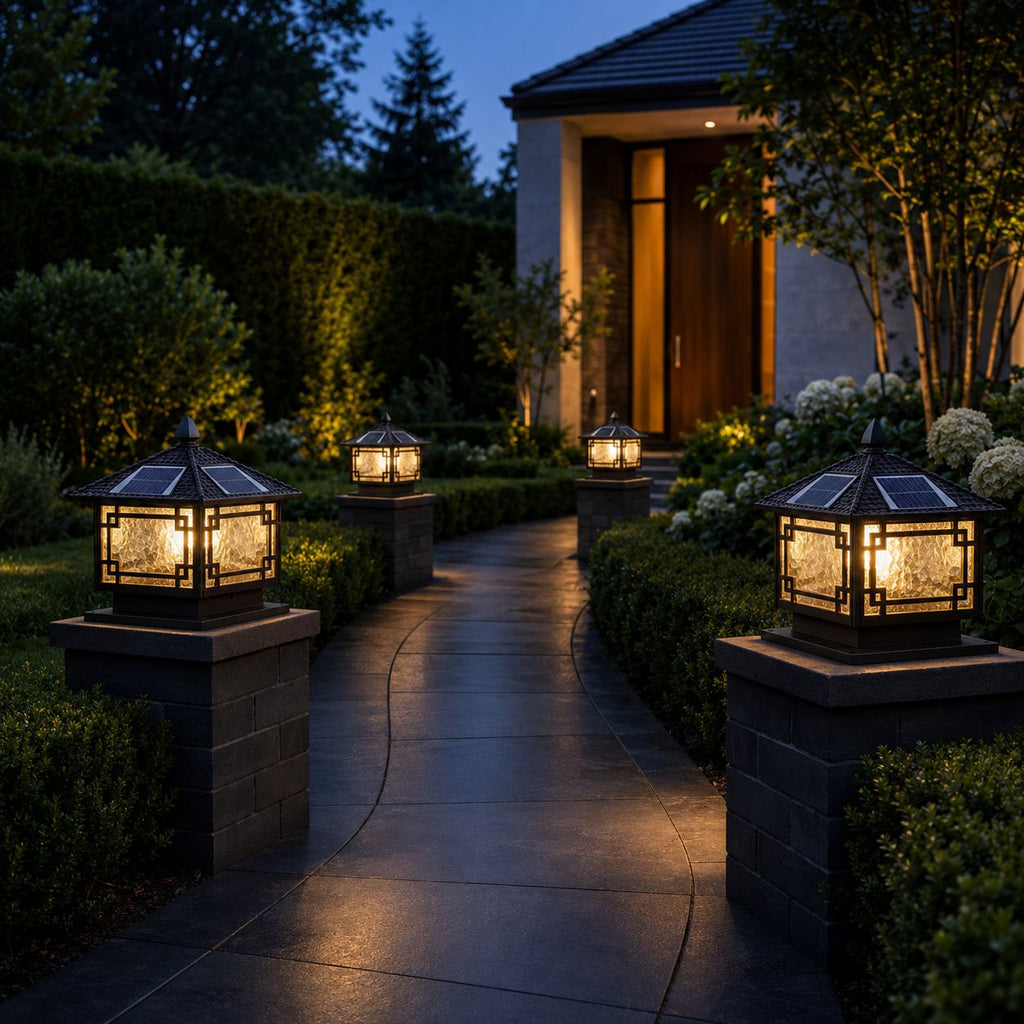 Four pillar lanterns lighting a planted path to a warmly lit front door