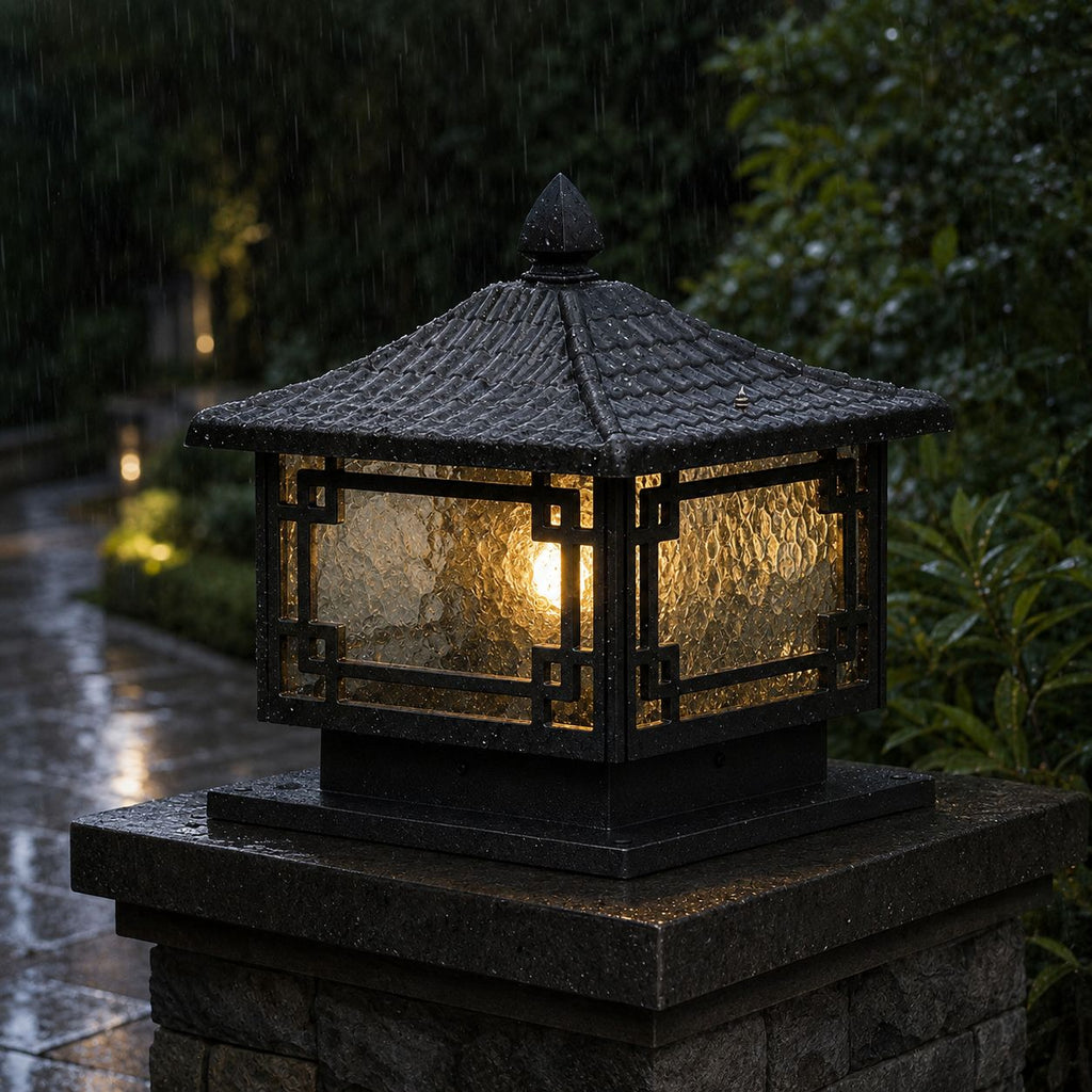 Traditional pillar lantern lit in heavy rain, water running over the frosted glass