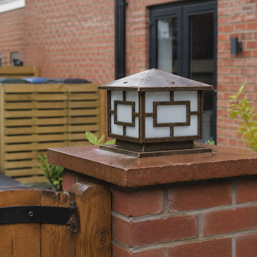 Pagoda pillar lights on red brick piers outside a house with a lit doorway