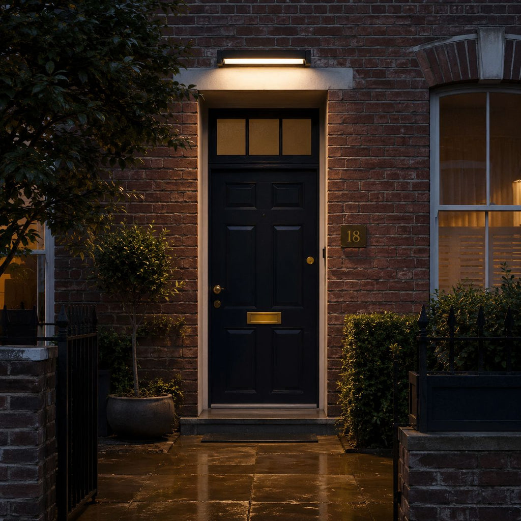 Rotating linear wall light above a dark front door on wet paving