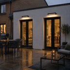 Linear wall light lighting a terrace table after rain