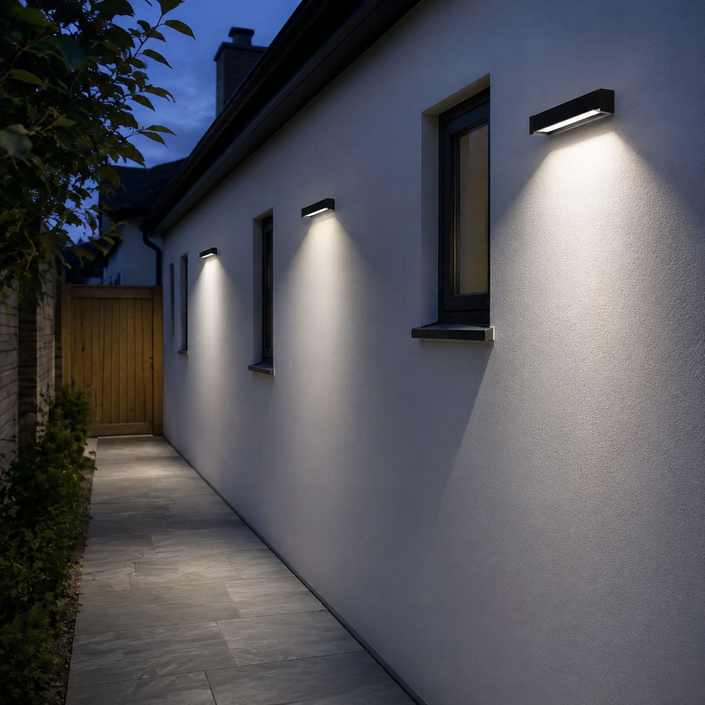 Row of linear wall lights along a white passage wall at dusk