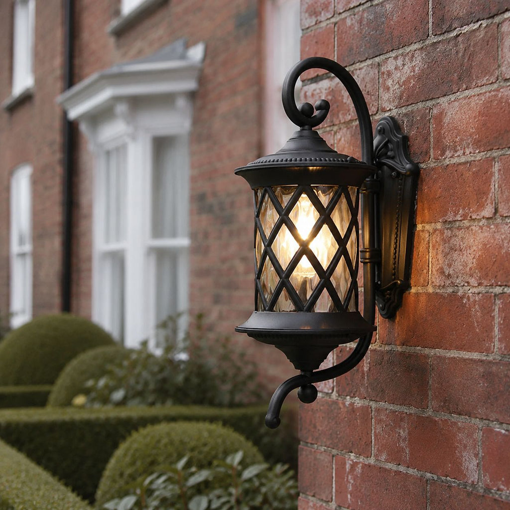 Lattice wall lantern on red brick beside clipped topiary