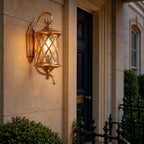 Coffee finish lattice wall lantern on render beside a dark blue front door