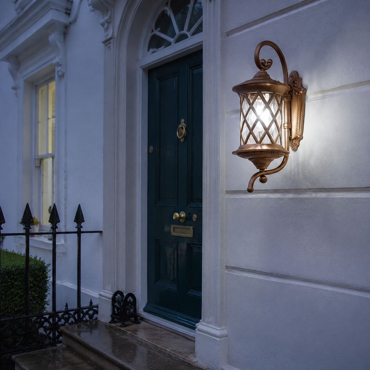 Lattice wall lantern on white render beside a teal door and iron railings