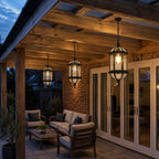 Three domed pendant lanterns under a timber pergola above outdoor seating