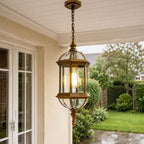 Domed pendant lantern under a white porch ceiling beside French doors