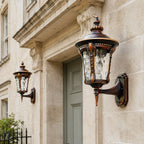 Two bronze hammered glass wall lanterns flanking a pale green panelled door