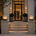 Two post cap lights on stone piers flanking the steps to a modern entrance