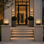 Two post cap lights on stone piers flanking the steps to a modern entrance