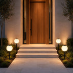 Solar globe path lights flanking stone steps to a timber front door