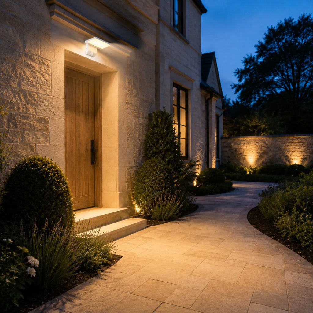 Angled LED wall light beside a timber front door lighting a paved path