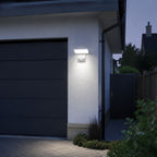 White angled LED wall light beside a grey garage door