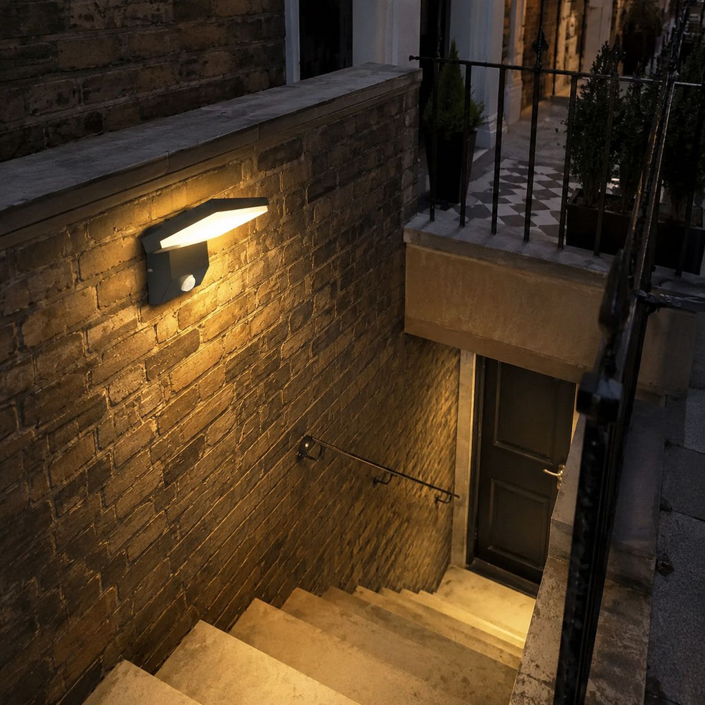 Angled LED wall light on a stone wall above basement steps