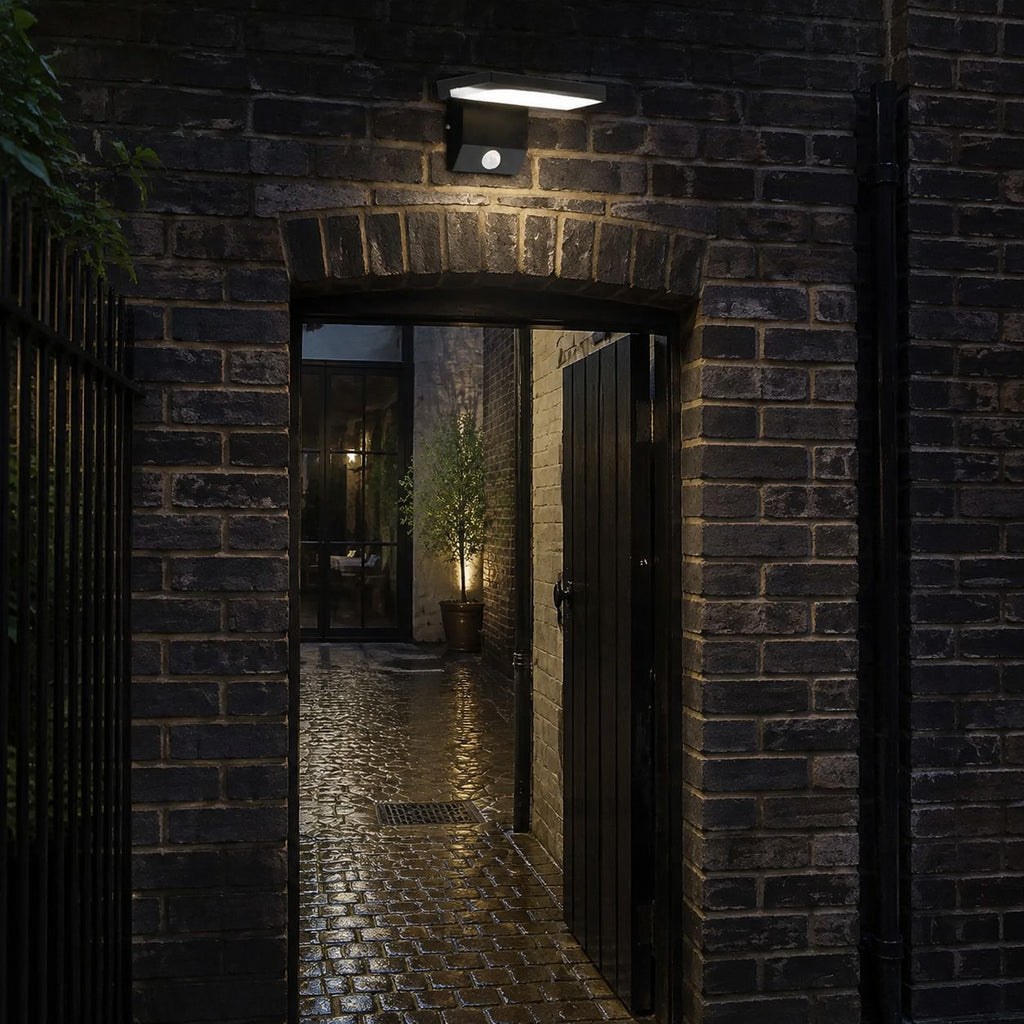 Angled LED wall light above a brick archway into a courtyard