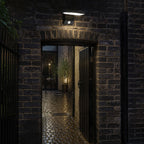 Angled LED wall light above a brick archway into a courtyard