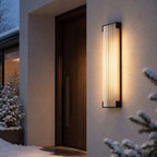 Fluted wall light beside a front door with snow-covered planting
