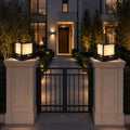 Pair of marble effect pillar lights on stone gate posts flanking iron gates