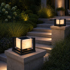 Two marble pillar lights on stone piers beside planted garden steps