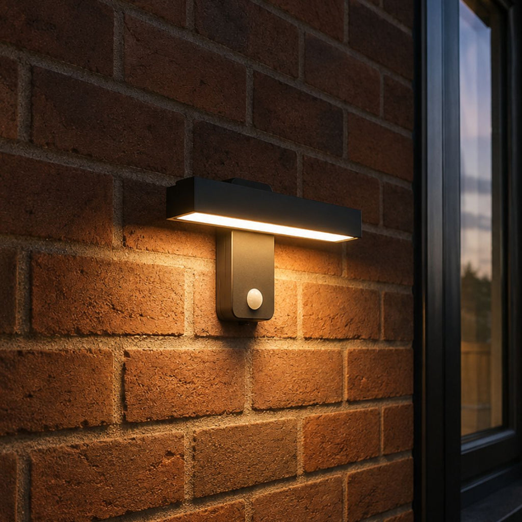 Linear LED bar wall light lit on red brick beside a window
