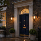 Two nautical caged sconces either side of a navy door under a fanlight