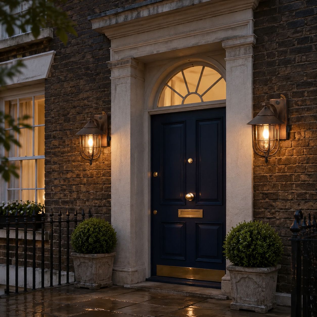 Two nautical caged sconces either side of a navy door under a fanlight