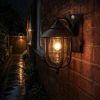 Nautical caged sconce lighting a wet brick passage at night