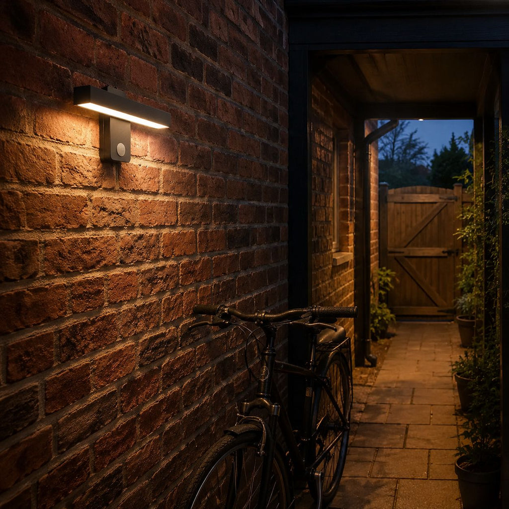 Linear LED bar wall light lighting a brick side passage with a bicycle