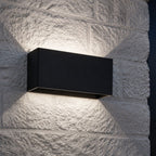 Up and down wall light on white stone throwing a soft hourglass of light
