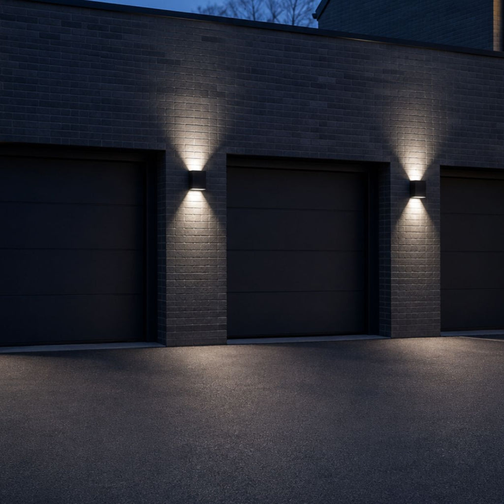 Three up and down wall lights spaced along a dark garage facade