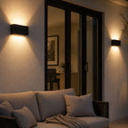 Two up and down wall lights beside glazed doors onto a lit terrace
