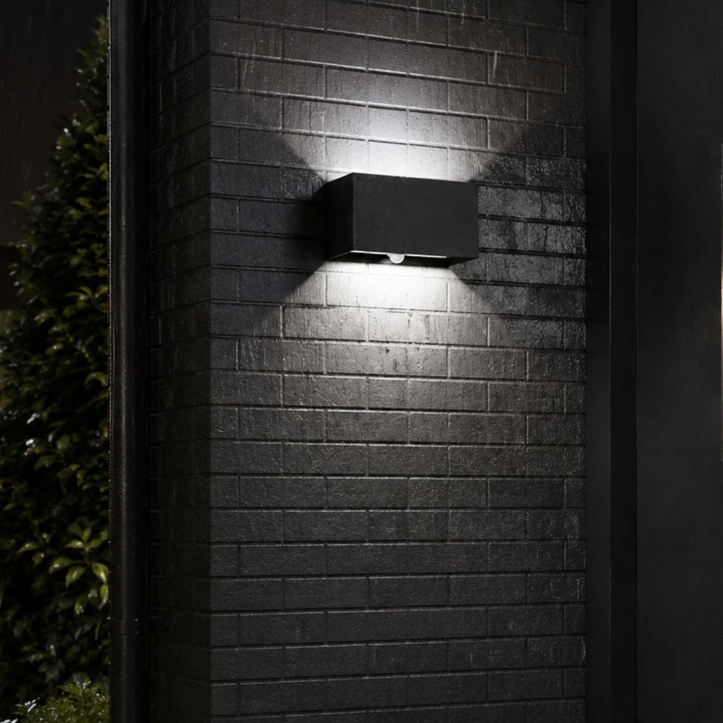 Up and down wall light on textured dark brick at night